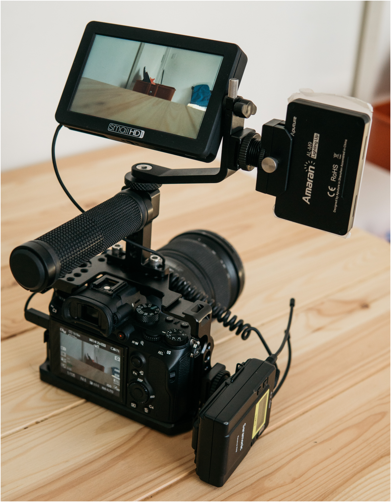 A camera setup sitting on a wooden table, shooting a video of a room. Photo from Unsplash.com
