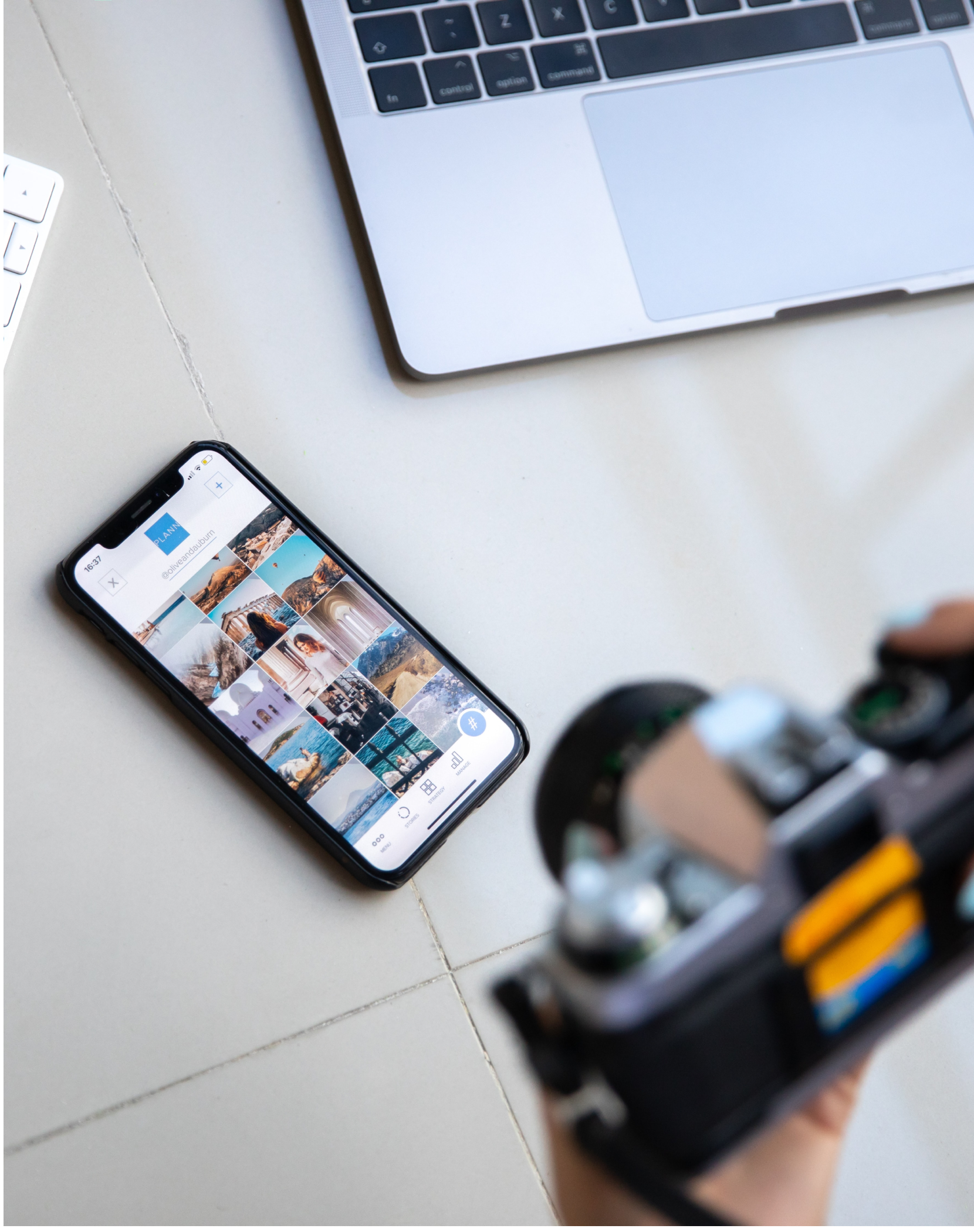 Taking a picture of a phone with a grid of photos on the screen, sitting in front of a laptop. Photo from Unsplash.com