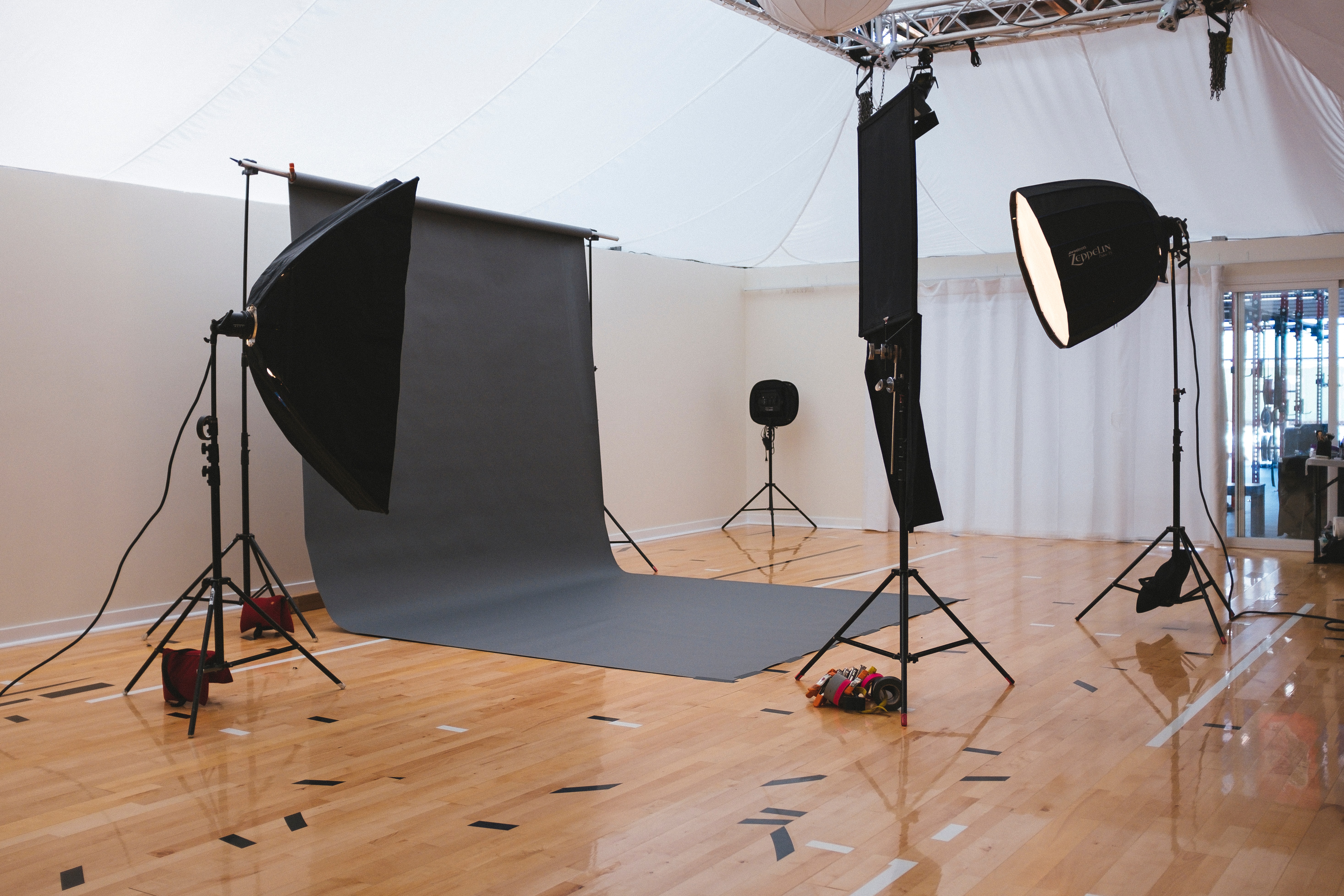 A studio setup with a black backdrop, two reflectors, and two other equipments. Photo from Unsplash.com